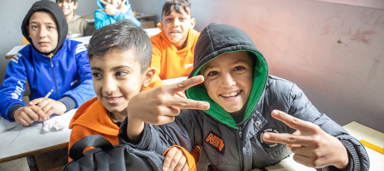 Childrens smiling and posing while taking photo inside the class