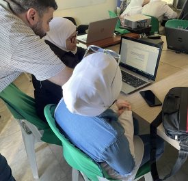 Children in a classroom learning using laptop